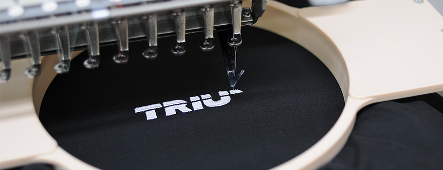 Embroidery machine with Trium logo